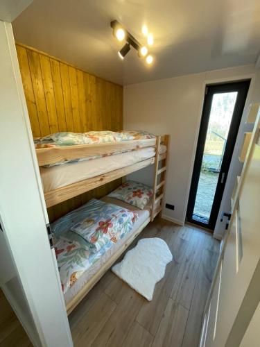 a room with two bunk beds and a window at Pochyła 80 home&spa in Rybnik