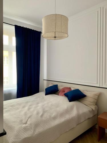 a bedroom with a large bed with blue curtains at Moon Deer in Jelenia Góra
