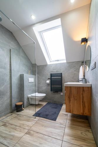 a bathroom with a shower and a sink and a skylight at Domek nad Potokiem 2 in Nowy Targ