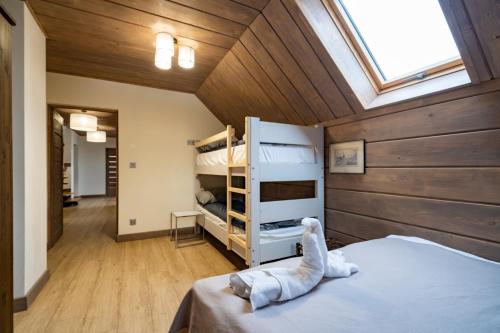 a attic room with a bed and bunk beds at Domek nad Potokiem 2 in Nowy Targ
