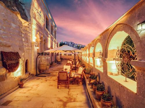 NarCappanar Cave Hotel的配有桌椅和遮阳伞的户外露台