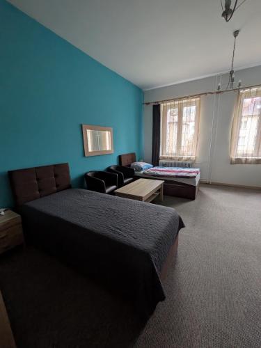 a bedroom with blue walls and a bed and a couch at Ubytování u Kováře in Ústí nad Labem