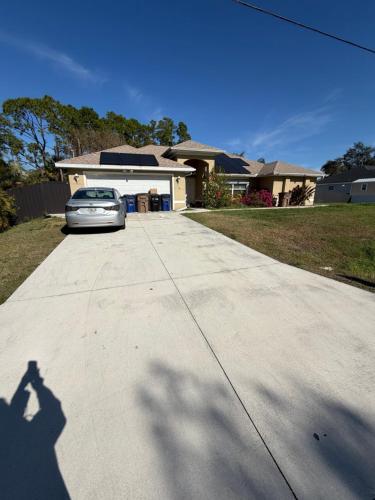 een schaduw van een auto geparkeerd op een oprit bij Florida Room in Lehigh Acres