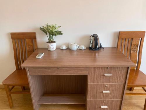 a wooden desk with a plant on top of it at Motel hoàng đế 1 in Chau Doc