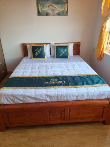a bed in a bedroom with a wooden bed frame at Motel hoàng đế 1 in Chau Doc