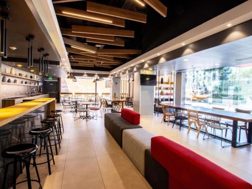 a restaurant with a bar and tables and chairs at ibis Tijuana in Tijuana