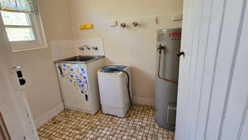 La petite salle de bains est pourvue d'un réfrigérateur et d'un évier. dans l'établissement Griffin lakeside, à Yarralumla