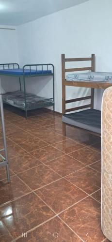 een kamer met een tafel en nog een tafel en een tegelvloer bij Chacara do Araujo in Mogi das Cruzes