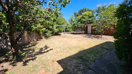 a yard with a fence and a basketball hoop at Griffin lakeside in Yarralumla