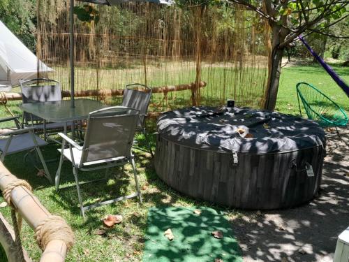 ein Tisch und Stühle in einem Garten mit einem Baum in der Unterkunft kubhotel in Tlaquiltenango