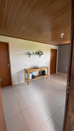 an empty room with a table and a ceiling at Chalé Sol e Luar 3 Ambientes in Santo Amaro