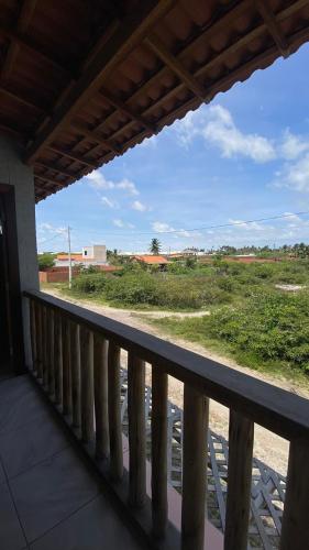 a balcony with a view of a field at Chalé Sol e Luar 3 Ambientes in Santo Amaro
