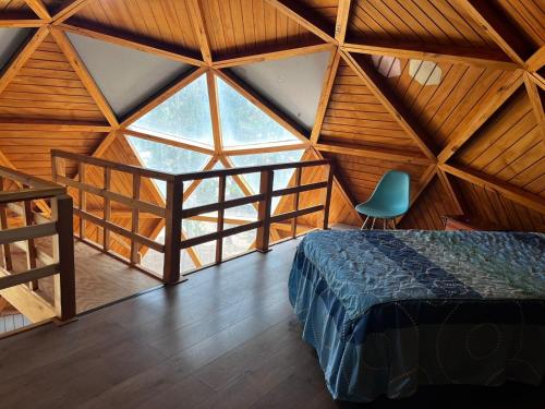 een slaapkamer met een bed in een kamer met houten plafonds bij Domo Algarrobo 2 in Algarrobo