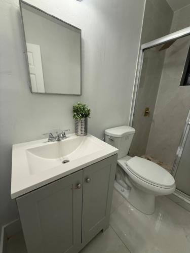 a bathroom with a sink and a toilet and a mirror at 2 bedroom 2467 in Miami