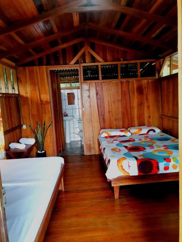 a bedroom with a bed in a room with wooden walls at Cabinas Cocalitos in Rincón