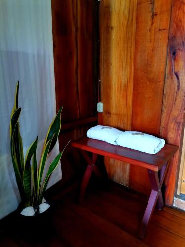 a bench with two pillows on it next to a plant at Cabinas Cocalitos in Rincón