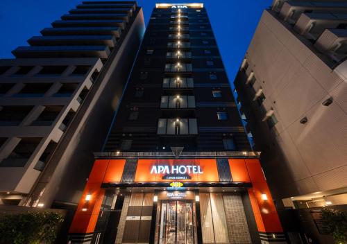 a building with an ar hotel sign in front of two tall buildings at APA Hotel Ayase Ekimae in Tokyo