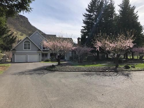 ein Haus mit rosa blühenden Bäumen in der Einfahrt in der Unterkunft RV Stays at Handsfull Farm site only in The Dalles