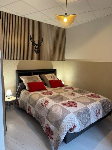 a bedroom with a large bed with red pillows at Studio de la Doller in Masevaux