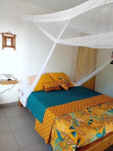 ein Schlafzimmer mit einem Bett mit Moskitonetz in der Unterkunft Studio vue mer avec cuisine et SDB in Capesterre