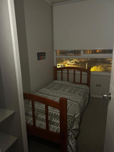 a bedroom with a bed with a view of a city at Departamento Puertas del Mar in La Serena