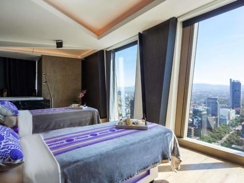 een slaapkamer met een bed en uitzicht op de stad bij Sofitel Mexico City Reforma in Mexico-Stad
