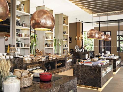 a restaurant with a buffet line in a room at Mövenpick Asara Resort & Spa Hua Hin in Hua Hin