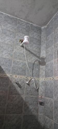 een douche met een wit object op een tegelvloer bij Pousada Renovo Beija-flor Espaço Terapêutico in Bertioga