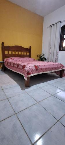 een bed in een kamer met een roze deken erop bij Pousada Renovo Beija-flor Espaço Terapêutico in Bertioga