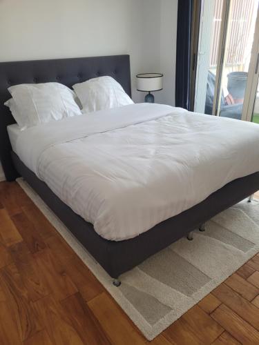 a bed with a white comforter on top of it at Rooftop apartment Cannes center - Parking in Cannes