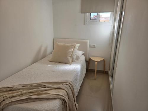 a small bedroom with a bed and a small table at Oliva Home in Los Cristianos