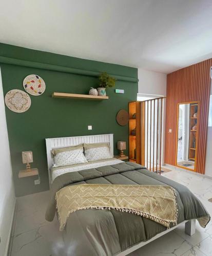 een slaapkamer met een groot bed met een groene muur bij Studio Sol e Sal in Santa Maria