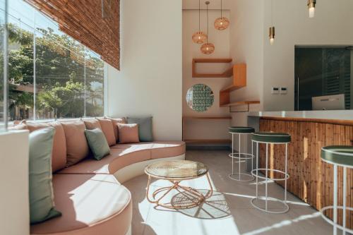 a living room with a couch and a bar at CALIXTA Hotel in Playa del Carmen
