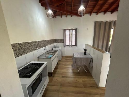 una cucina con mobili bianchi e un forno a piano cottura di Oasis na montanha a Bueno Brandão