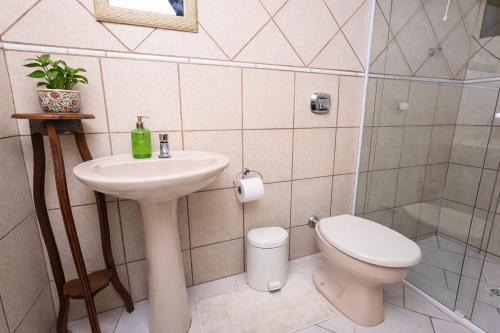 une salle de bains avec lavabo et toilettes dans l'établissement Suíte Iberê - Pousada Jussara, à Joinville