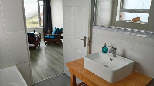 a bathroom with a white sink and a mirror at Swallow's Beach in Port Elizabeth