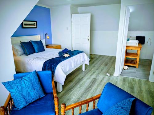 a bedroom with a bed and a couch at Swallow's Beach in Port Elizabeth
