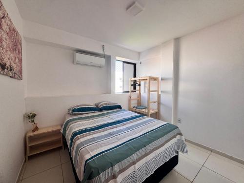 a bedroom with a bed with blue pillows on it at Apê aconchegante perto do mar in Cabedelo