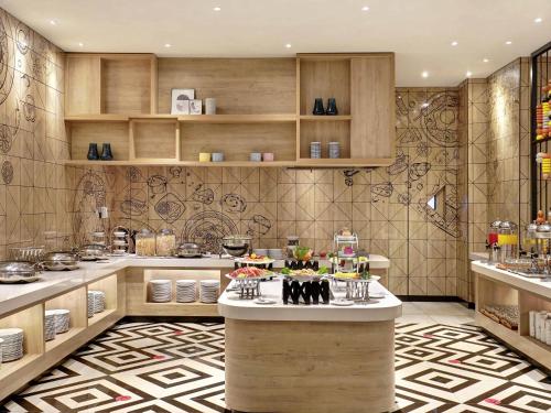 a kitchen with a table with food on it at Ibis Samarinda in Samarinda