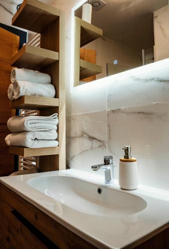 a bathroom with a white sink and towels at Sky Lux Cozy Nest in Jahorina