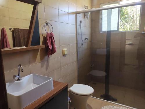 een badkamer met een wastafel, een toilet en een douche bij Chacara do japonês 