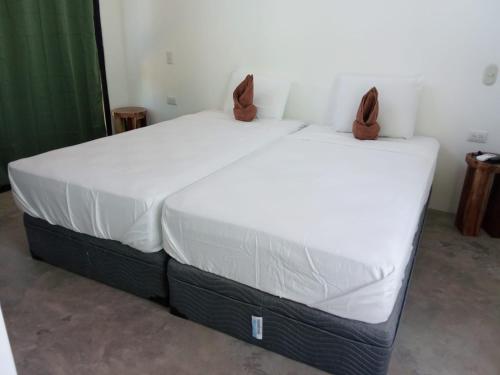 a bed in a room with a white mattress at Jungle surf Villa in El Zonte