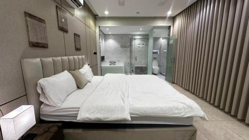 a bedroom with a large white bed and a bathroom at شاليه ايلان المدينة المنورة in Medina