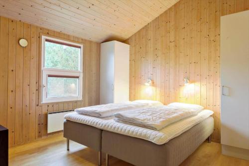 een slaapkamer met een bed in een houten wand bij 990-Thisted-Spanggardsvej-29 in Torsted