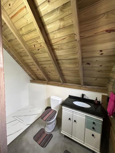 a bathroom with a toilet and a sink at pousada Aroeira, G Embaú in Palhoça