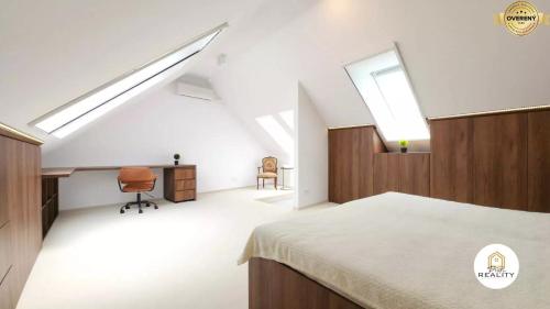 a bedroom with a bed and a desk and a chair at Mezonet Jarková in Prešov