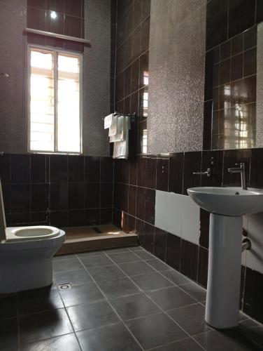 a bathroom with a toilet and a sink at Andweruth Residences in Abuja