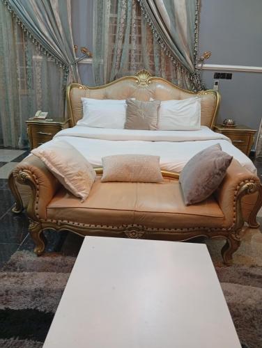 a bed with a couch with pillows on it at Andweruth Residences in Abuja