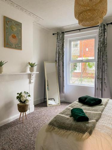 una camera con letto, finestra e specchio di Cozy home a Kings Lynn