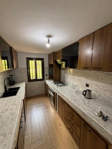 een keuken met houten kasten en een aanrechtblad bij Villa oasis, Résidence Nianing in Nianing